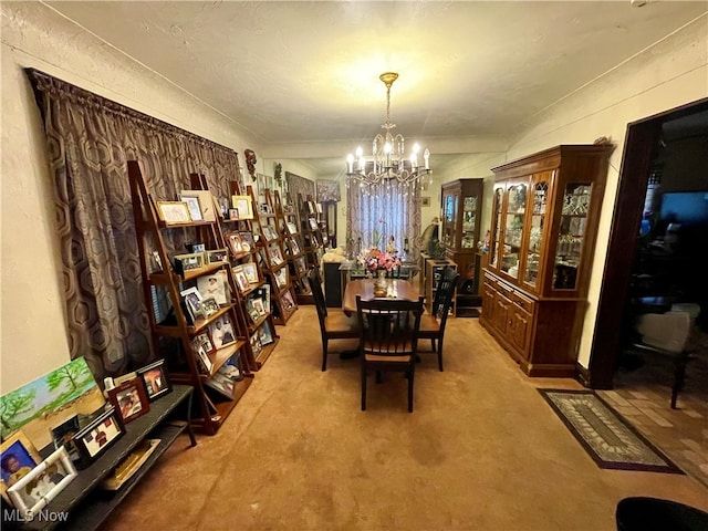 dining room featuring light colored carpet, a textured ceiling, and a chandelier