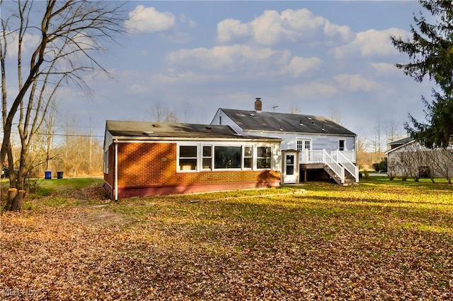 rear view of property with a wooden deck and a yard