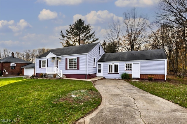 view of front of house featuring a garage, an outbuilding, and a front lawn