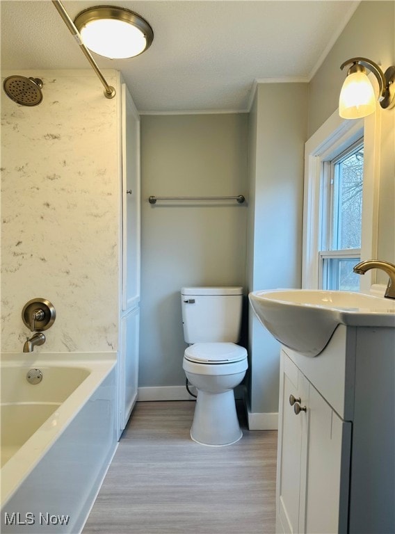 full bathroom with washtub / shower combination, crown molding, toilet, vanity, and hardwood / wood-style flooring