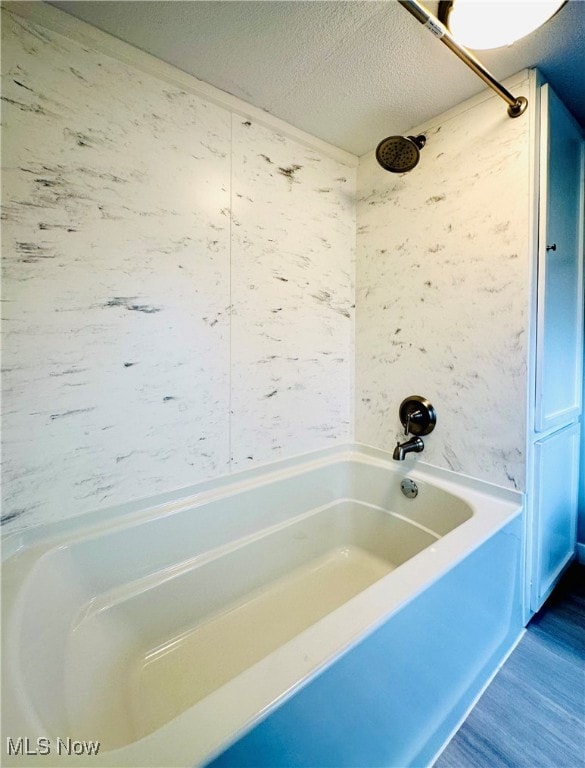 bathroom featuring shower / bathing tub combination, a textured ceiling, and hardwood / wood-style flooring