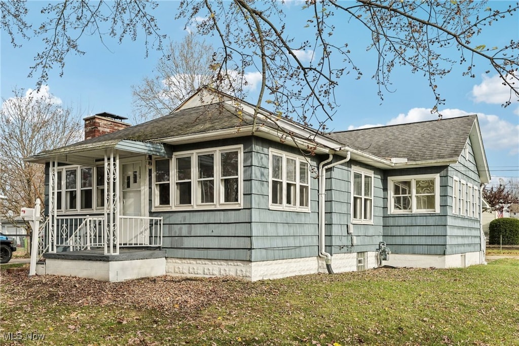 rear view of house featuring a yard