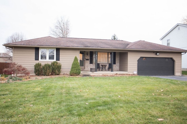 ranch-style home with covered porch, a garage, and a front yard