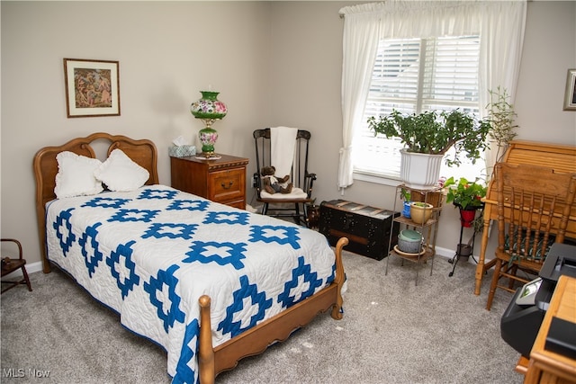 carpeted bedroom featuring multiple windows and baseboards