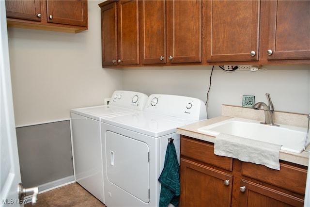 clothes washing area featuring cabinets, sink, and washing machine and clothes dryer