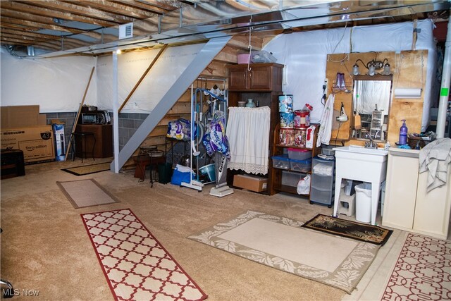 unfinished basement with visible vents and stairway