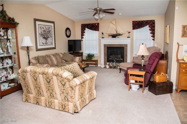 living room featuring vaulted ceiling, ceiling fan, carpet floors, and a glass covered fireplace