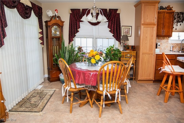 tiled dining space with sink, a wealth of natural light, and an inviting chandelier