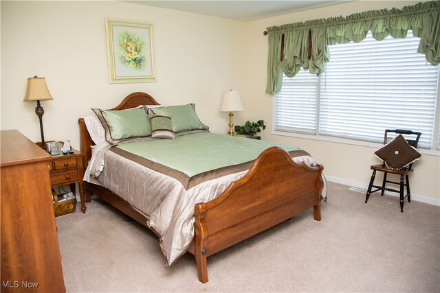 bedroom featuring carpet, multiple windows, and baseboards