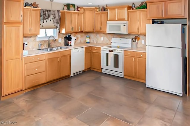 kitchen featuring white appliances, light countertops, a sink, and light brown cabinetry