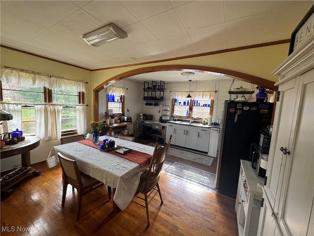 dining room with crown molding, hardwood / wood-style floors, and sink