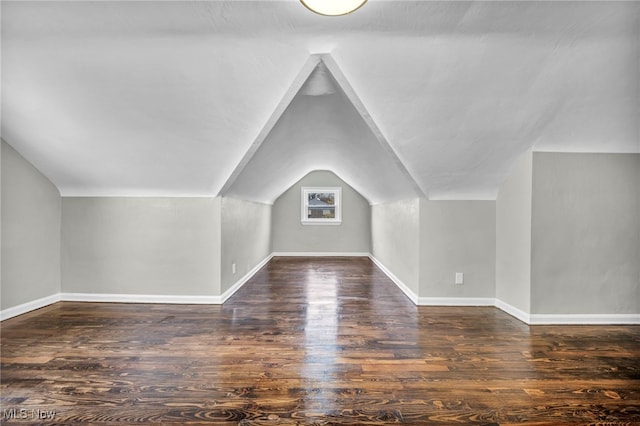 bonus room with dark hardwood / wood-style flooring and vaulted ceiling