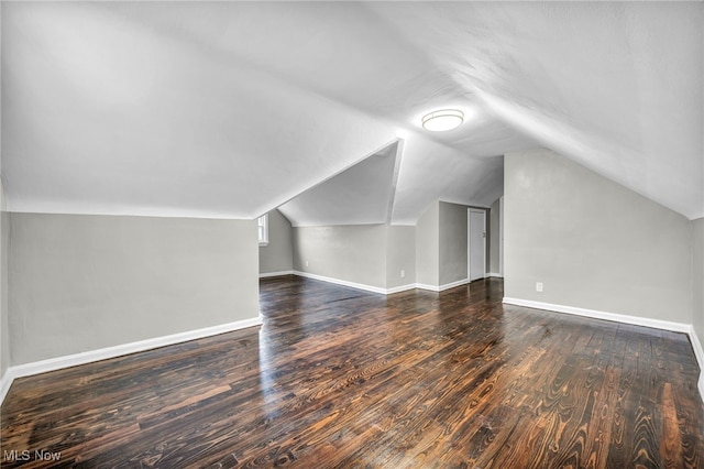 additional living space with dark hardwood / wood-style flooring and lofted ceiling