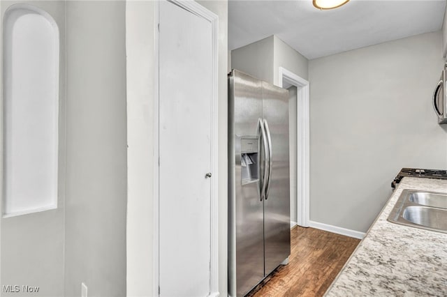 kitchen with stainless steel fridge, sink, and dark wood-type flooring