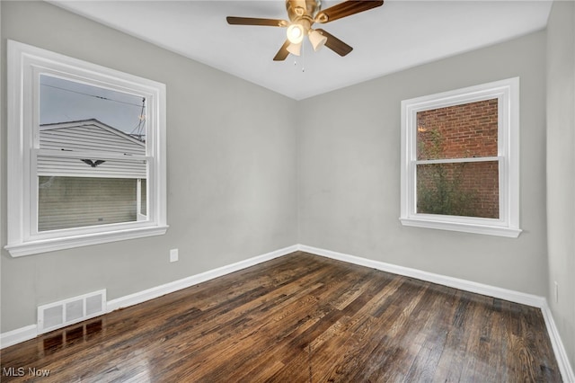 empty room with ceiling fan and dark wood-type flooring