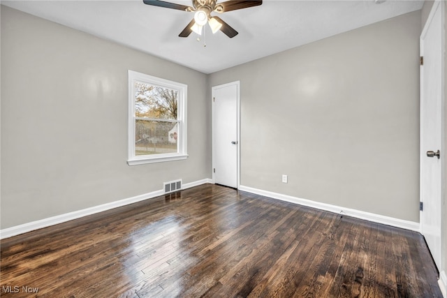 empty room with ceiling fan and dark wood-type flooring