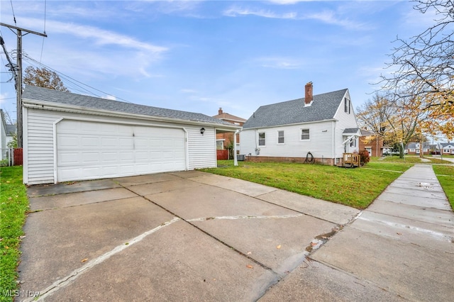 exterior space with a garage, an outdoor structure, and a lawn