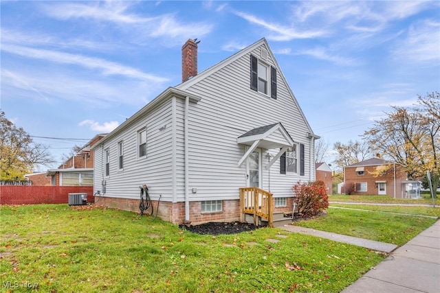 exterior space featuring a yard and central AC