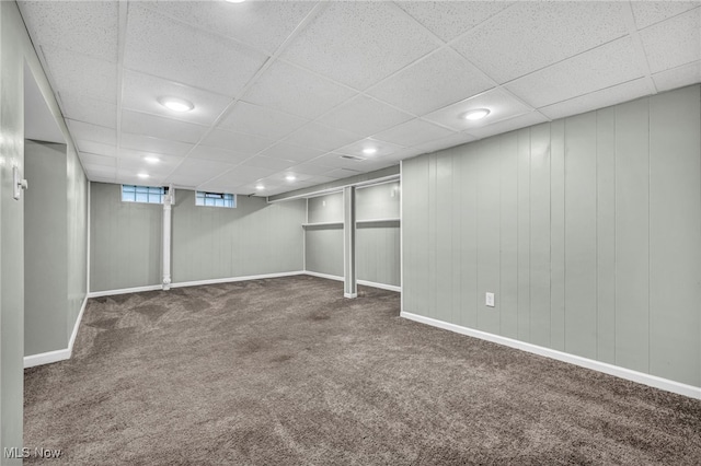 basement with a drop ceiling and dark carpet