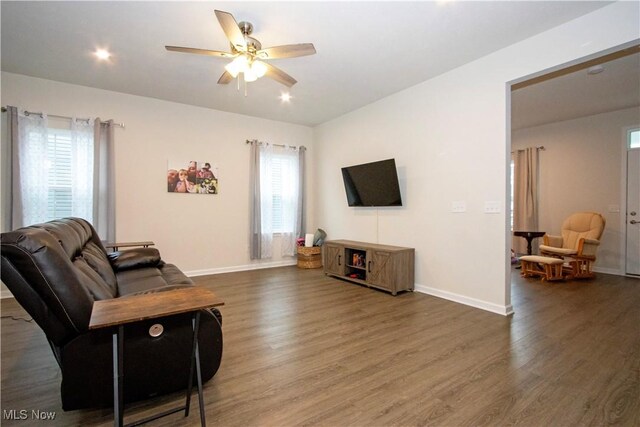 living room with ceiling fan and dark wood-type flooring