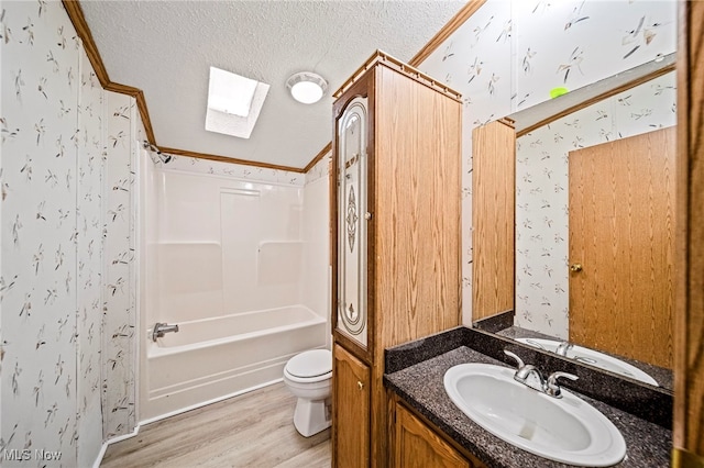 full bathroom with toilet, bathing tub / shower combination, wood-type flooring, a skylight, and a textured ceiling