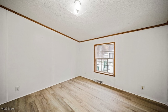 unfurnished room with ornamental molding, a textured ceiling, and light wood-type flooring