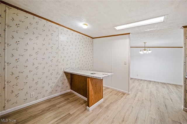 interior space with crown molding, an inviting chandelier, a textured ceiling, and light wood-type flooring