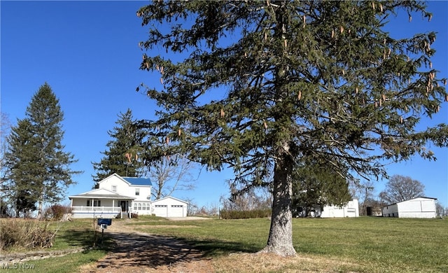 view of yard with covered porch and a garage