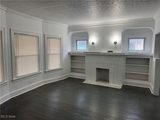 unfurnished living room featuring a textured ceiling, dark hardwood / wood-style floors, a brick fireplace, and a wealth of natural light