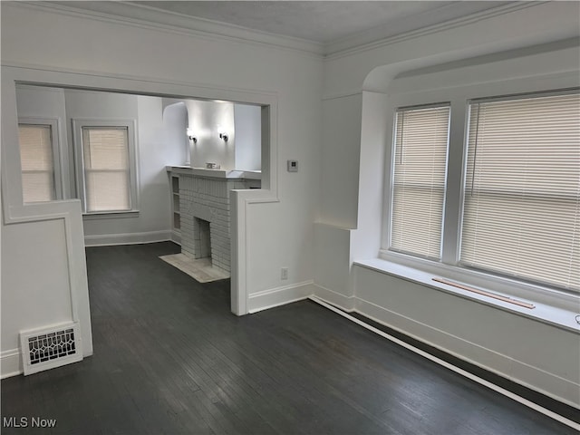 unfurnished living room with dark hardwood / wood-style floors, ornamental molding, and a fireplace