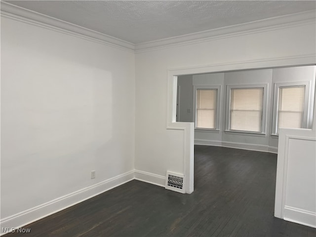 unfurnished room with dark hardwood / wood-style flooring, a textured ceiling, and ornamental molding