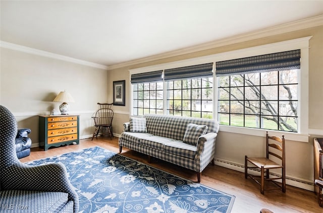 sitting room featuring wood-type flooring, ornamental molding, and baseboard heating