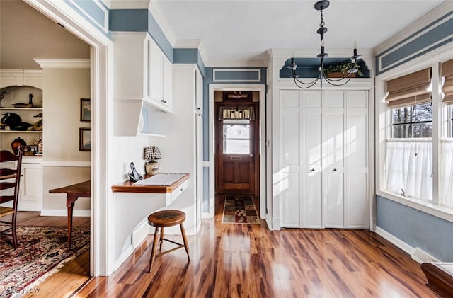 foyer entrance featuring wood-type flooring, a wealth of natural light, and crown molding