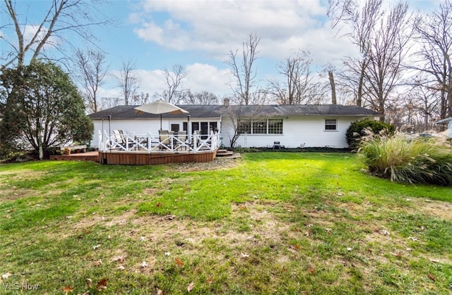 rear view of property with a yard and a wooden deck