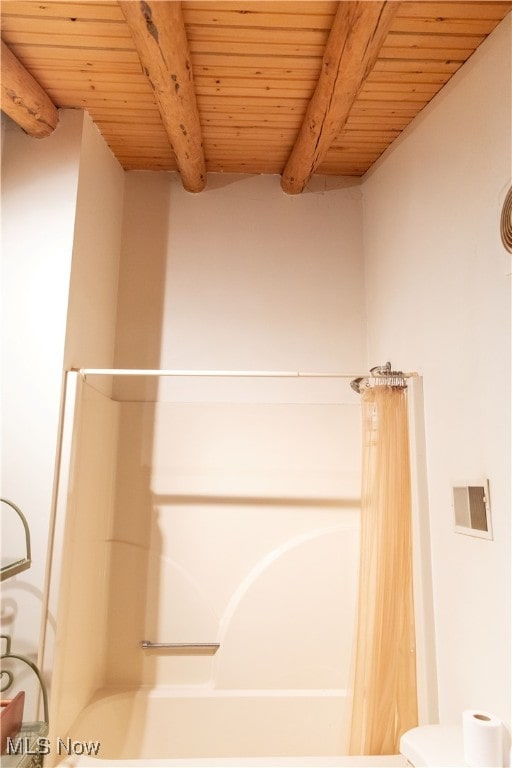 bathroom with beam ceiling, wooden ceiling, and shower / tub combo with curtain