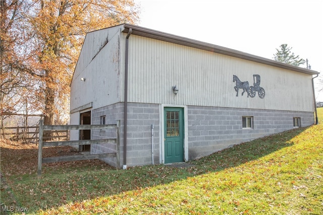 view of property exterior featuring an outbuilding and a lawn