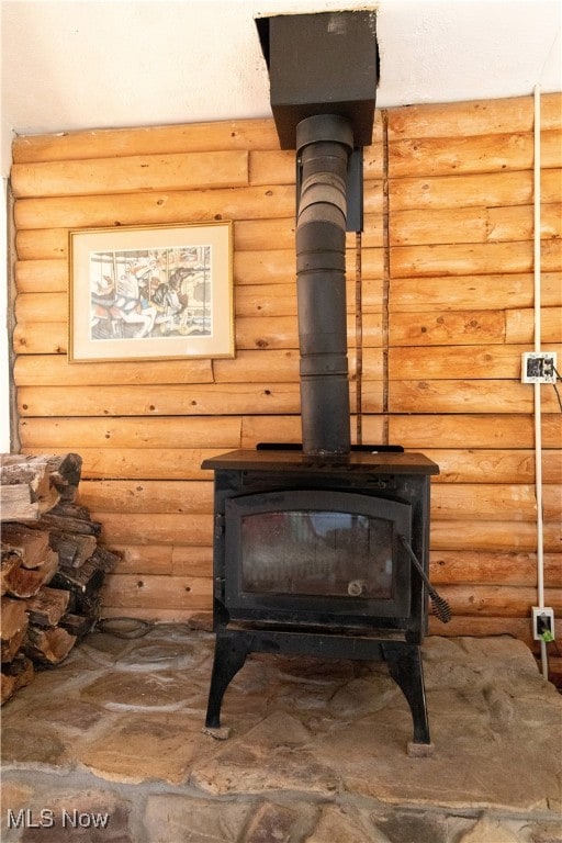 details featuring a wood stove and rustic walls