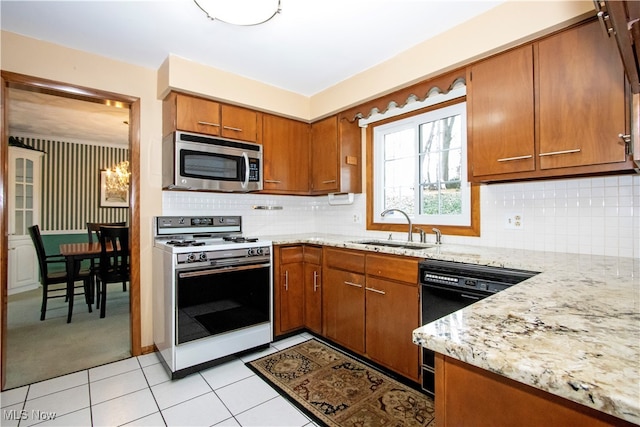 kitchen with tasteful backsplash, white range, sink, light tile patterned floors, and black dishwasher