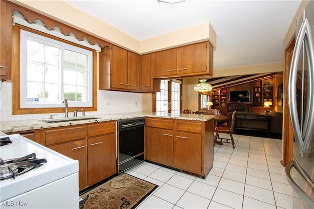 kitchen featuring stainless steel fridge, dishwasher, a healthy amount of sunlight, and kitchen peninsula