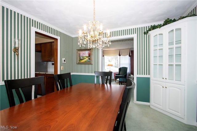 carpeted dining space with ornamental molding and an inviting chandelier