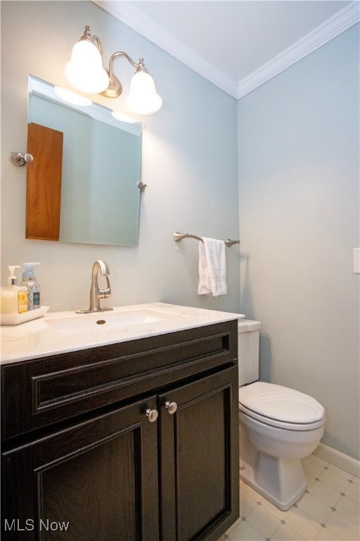 bathroom featuring toilet, vanity, and ornamental molding