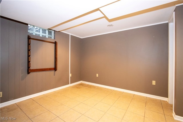 empty room featuring wooden walls and tile patterned flooring