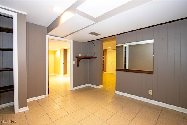 tiled spare room with wood walls