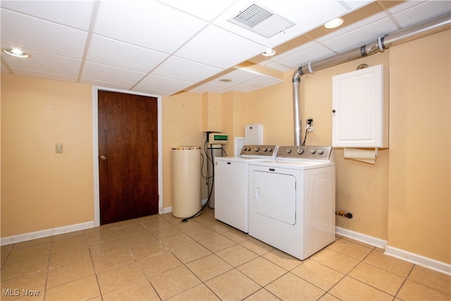 clothes washing area with washer and dryer and light tile patterned floors