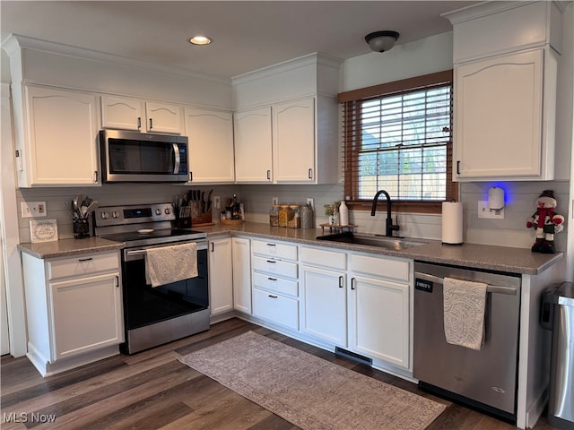 kitchen featuring white cabinets, sink, tasteful backsplash, dark hardwood / wood-style flooring, and stainless steel appliances