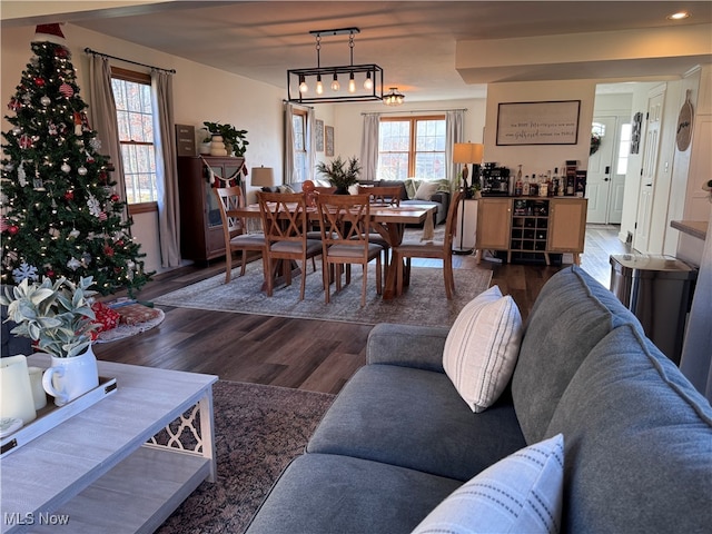 living room with bar area and dark wood-type flooring