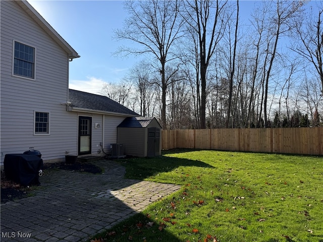 view of yard with central AC unit and a shed