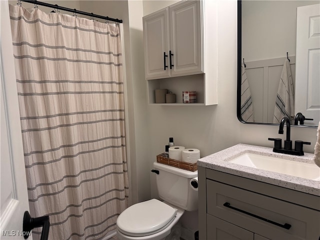 bathroom with vanity, toilet, and curtained shower