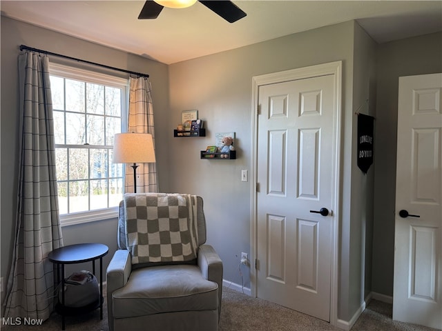 living area with carpet and ceiling fan