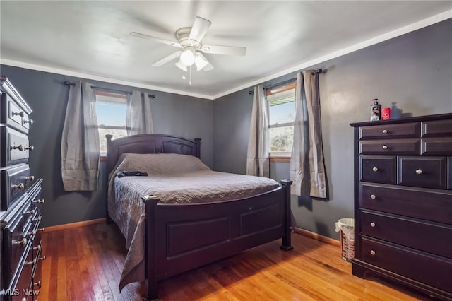 bedroom with hardwood / wood-style flooring, ceiling fan, and ornamental molding